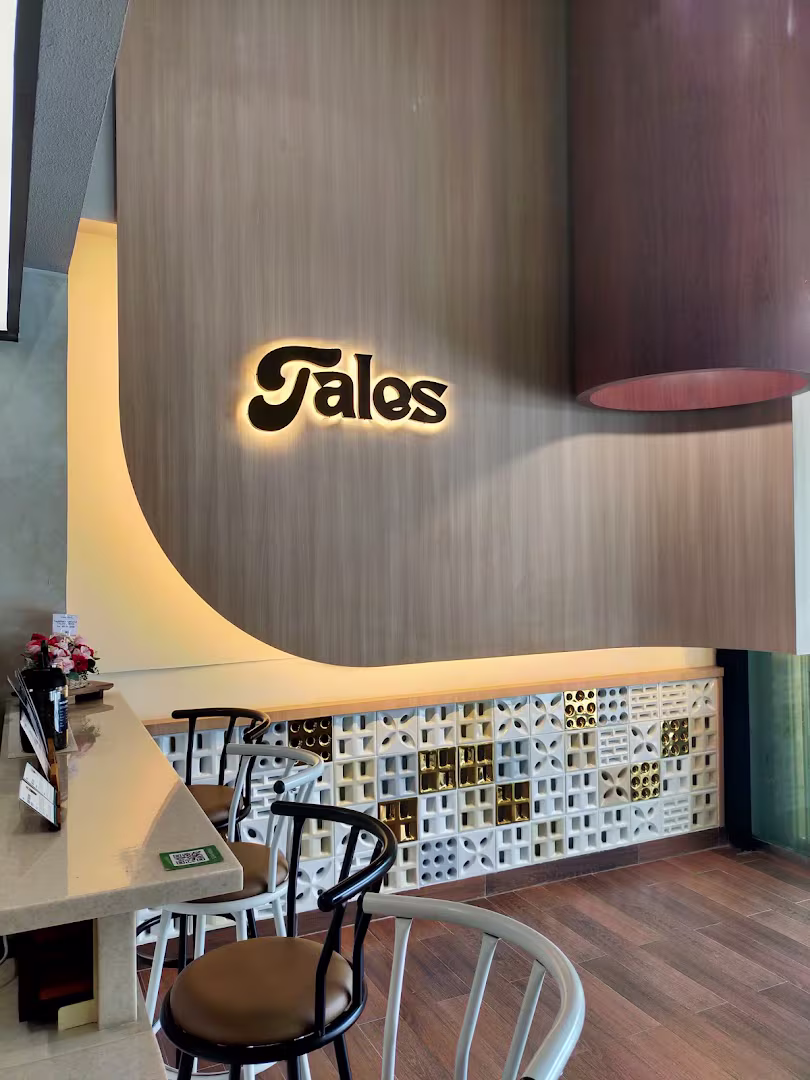 Illuminated Tales Coffee signboard wall with bar stools