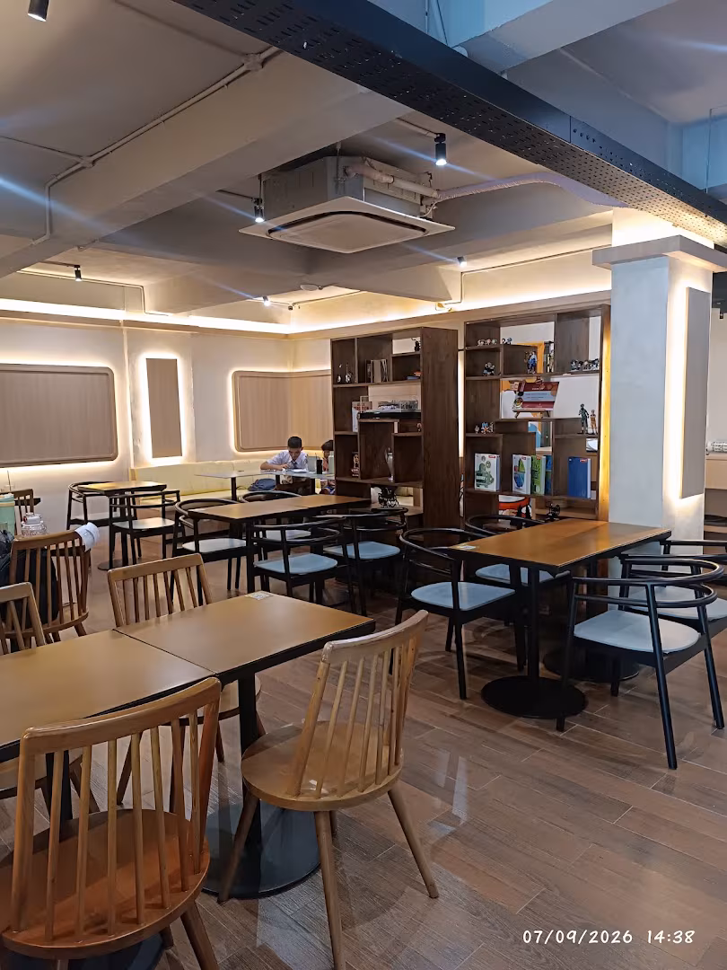 Indoor seating area with wooden tables and bookshelves